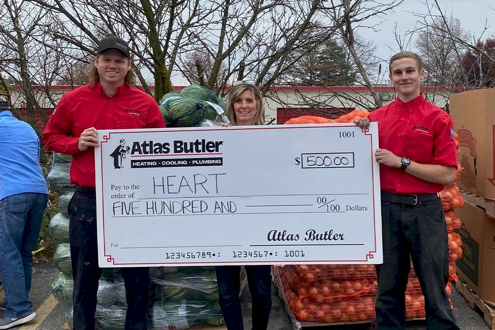 Atlas Butler HVAC Technicians holding a donation check for the Mid-Ohio HEART (Helping Eastside and Reynoldsburg Thrive) Market Model Food Pantry.